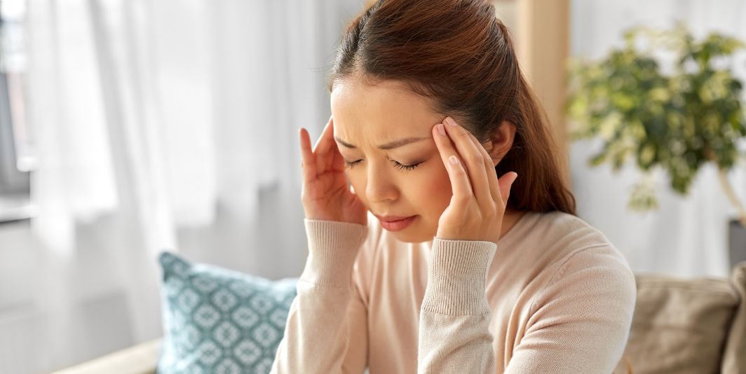 woman holding head in pain