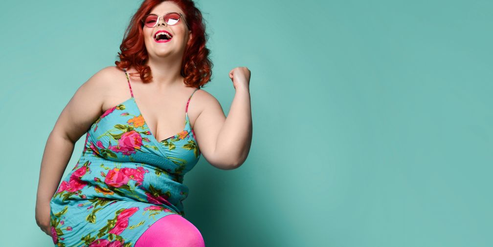 Woman with Red hair in a blue dress with pink flowers on it dancing