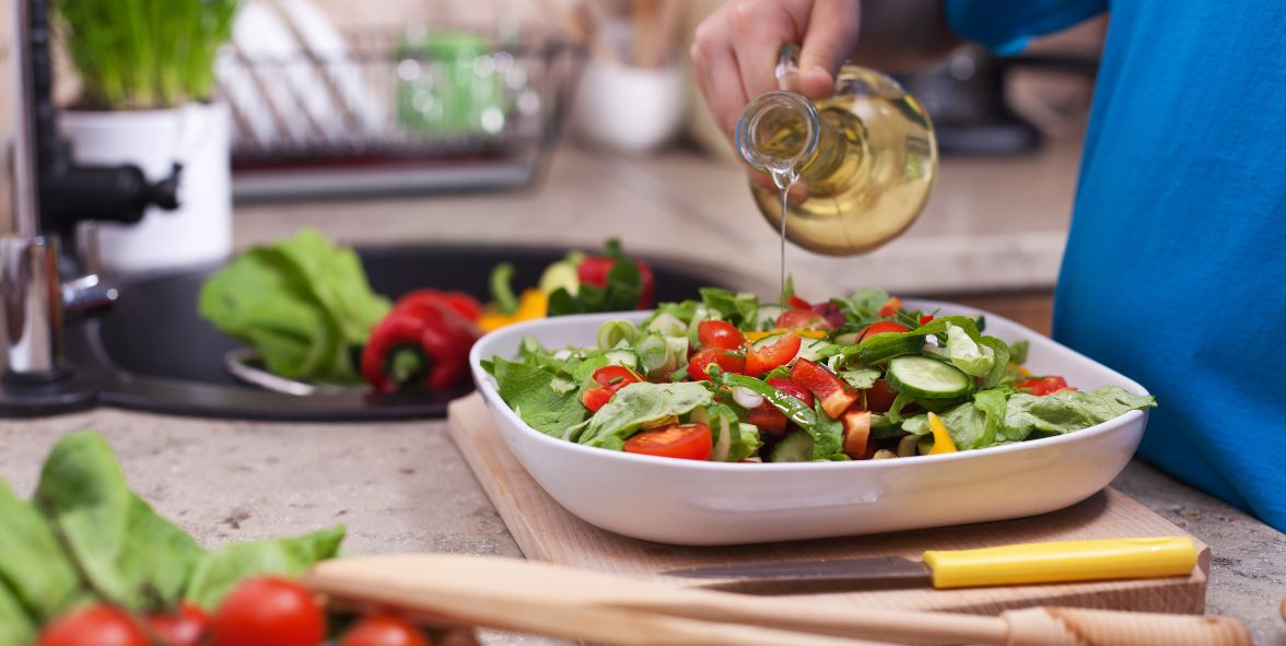 oil based dressing being poured over a salad 