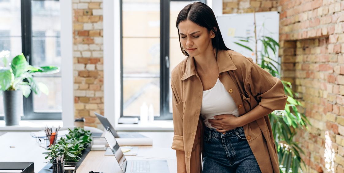 woman holding stomach in pain 