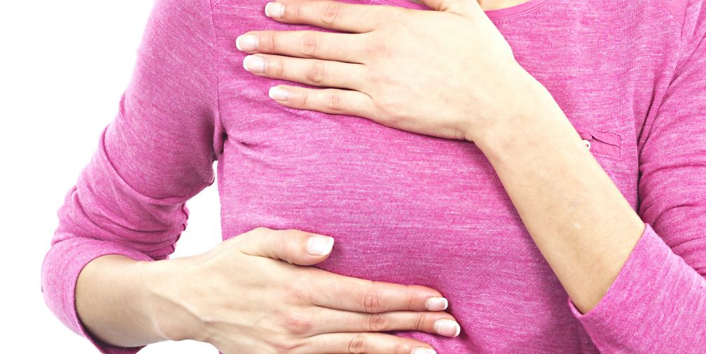 Woman checking for breast cancer 