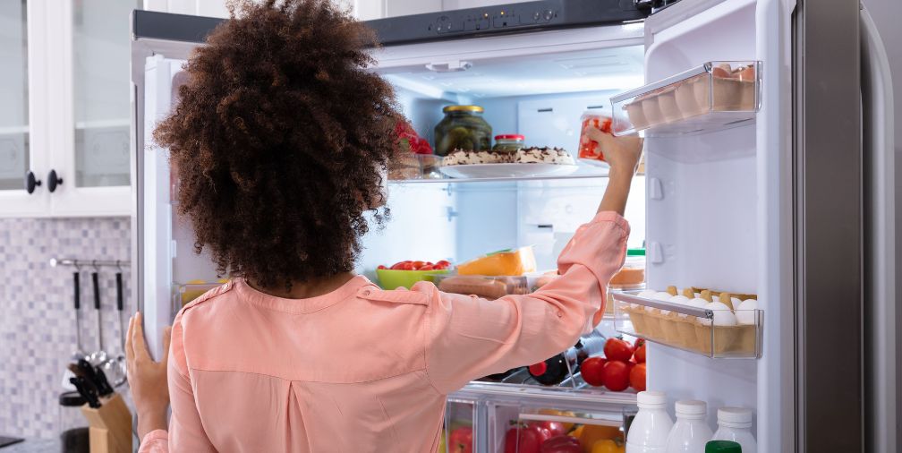 Woman going through fridge 