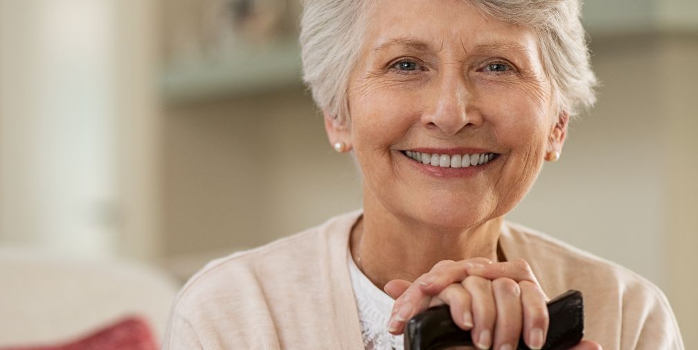 Elderly woman smiling with cane