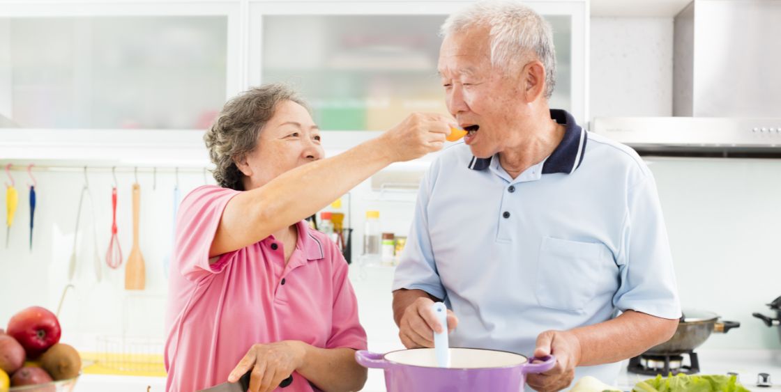 Asian descent elderly woman and man making dinner