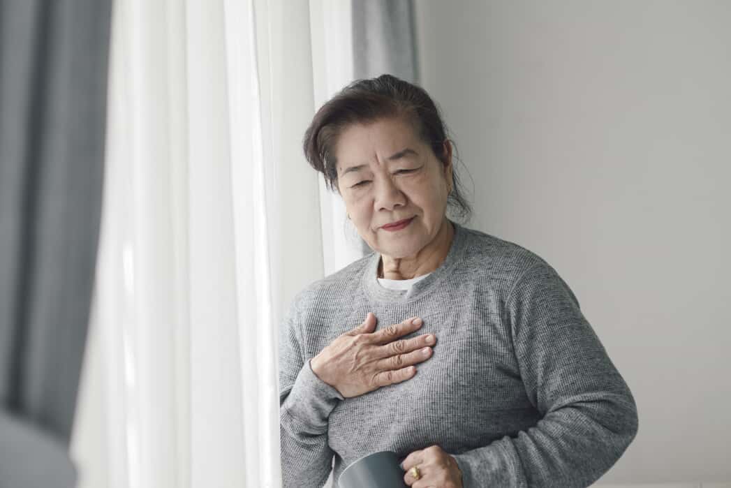 Woman Holding Her Chest 