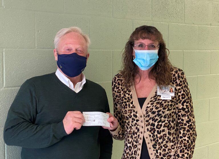 Steve Barnett, DHA, CRNA, FACHE, McKenzie President/CEO receives a check from Rebecca Cambridge, McKenzie Auxiliary President.