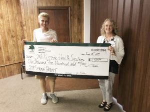 2 women holding a large check